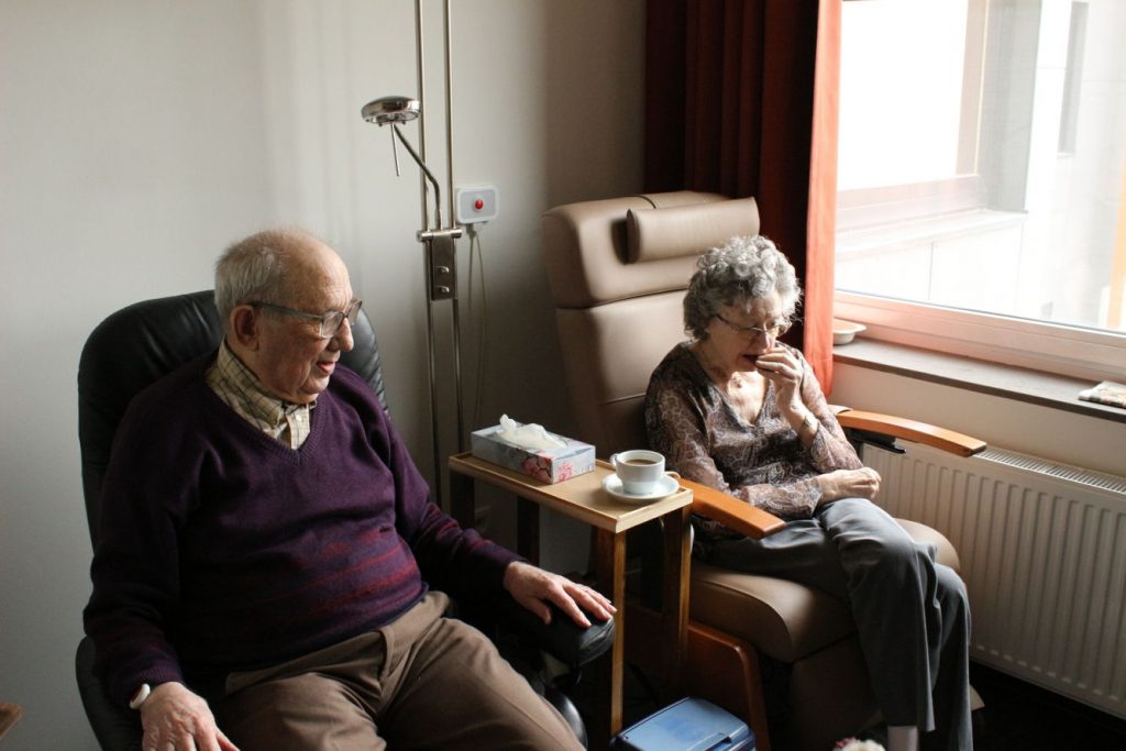 älteres Ehepaar sitzend im Wohnzimmer