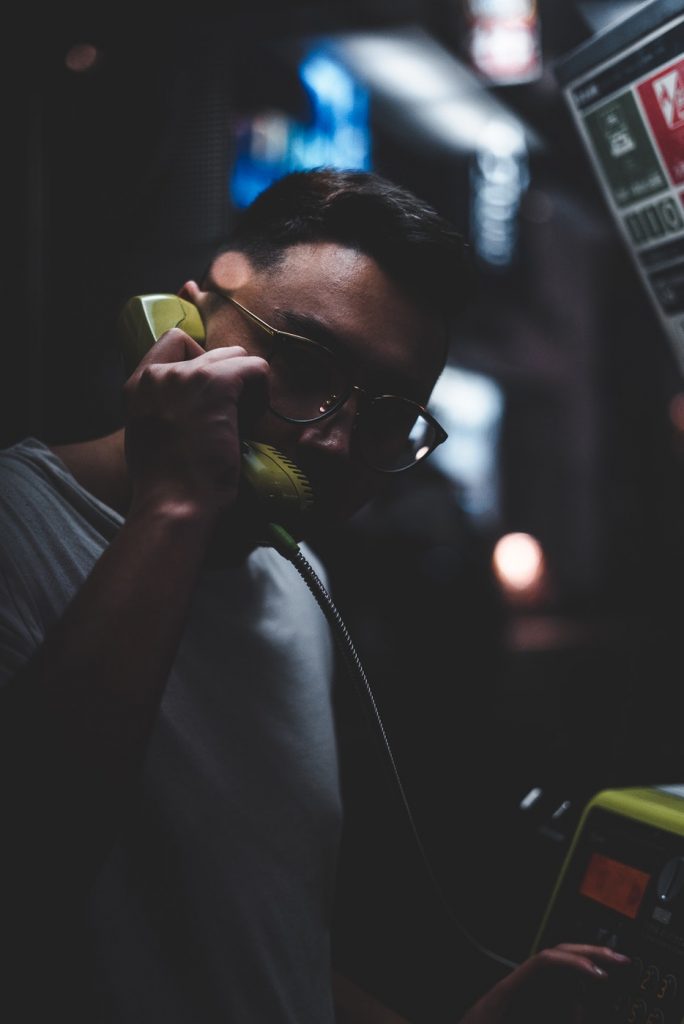 Mann an Telefonzelle