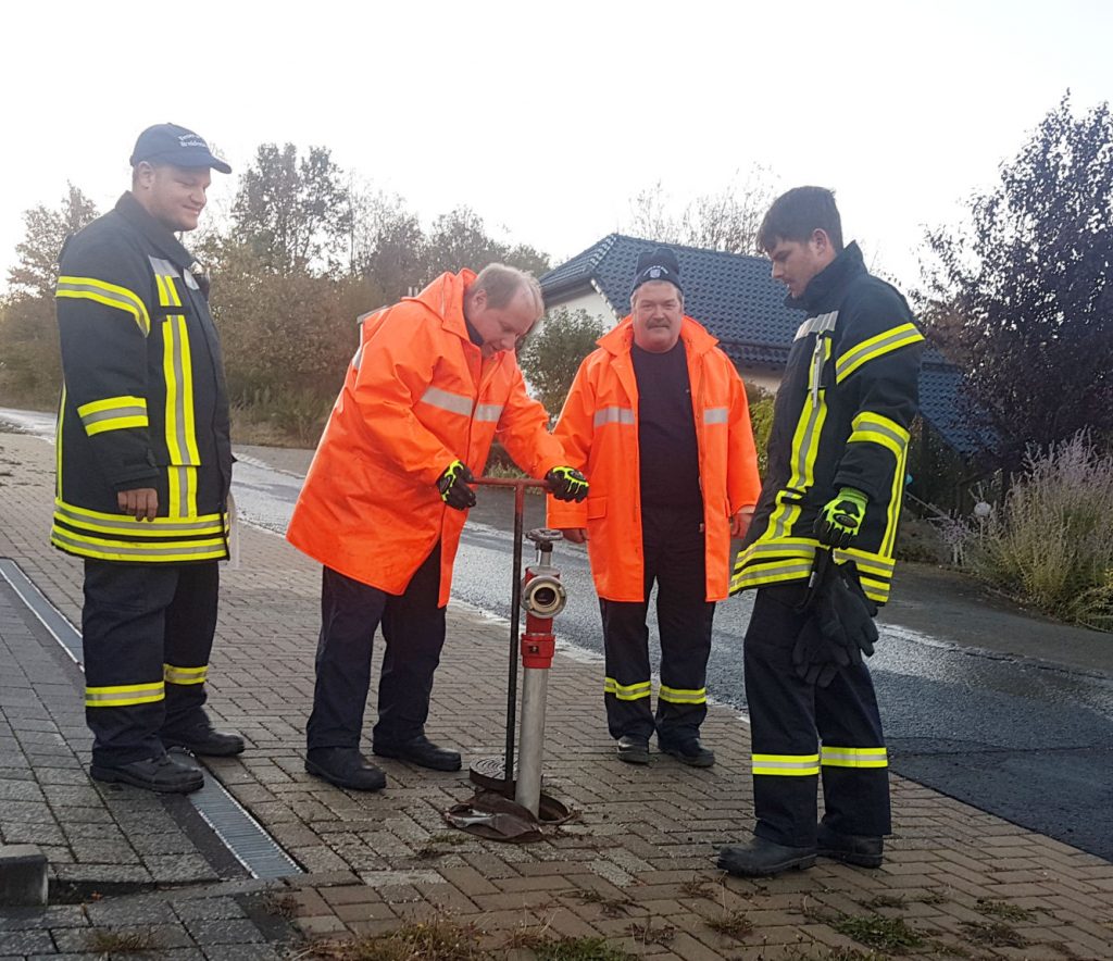 4 Feuerwehrleute bei der Hydrantenspülung