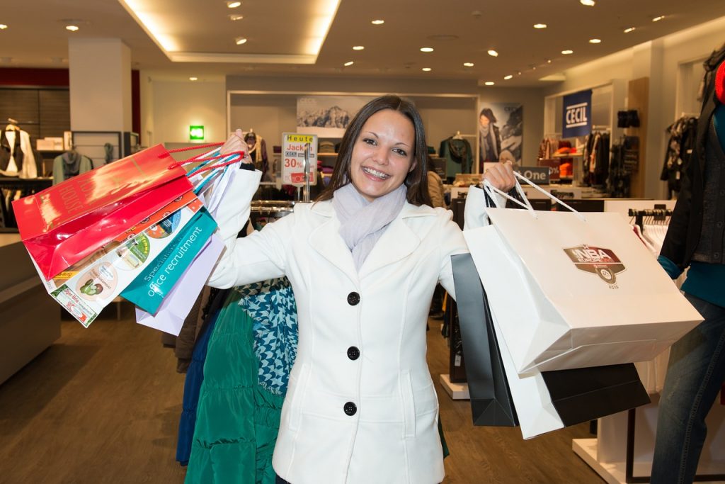 Frau im Laden mit vielen Einkaufstaschen