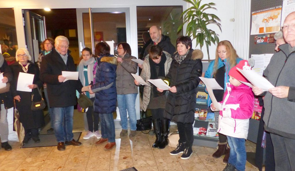 Eine Gruppe von winterlich gekleideten MEnschen aller Altersgruppen stehen - Liedblätter haltend - im Foyer des FeG-Gemeindehauses in Biedenkopf und singen.erner)