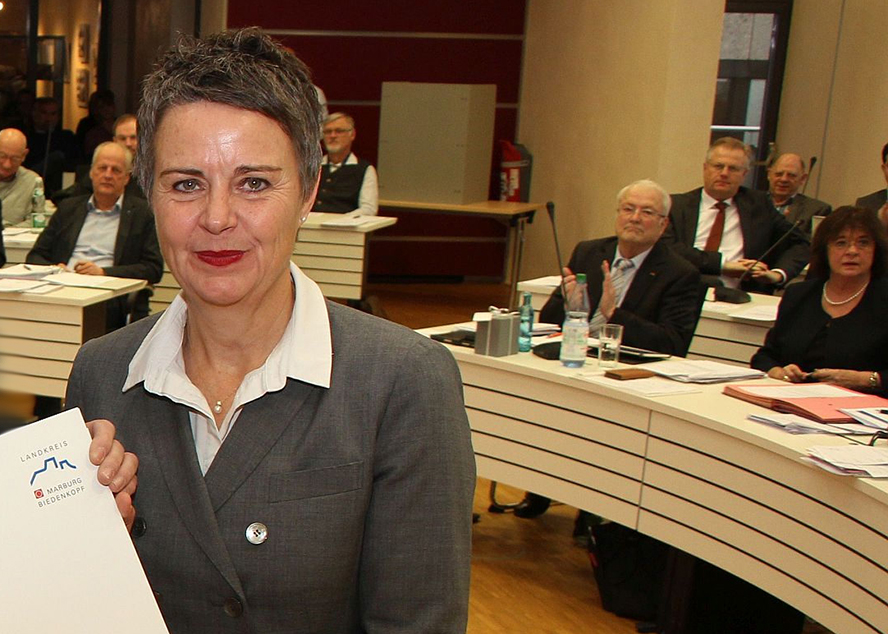 Landrätin Kirsten Fründt im Rahmen der Ernennung. Im Hintergrund sitzen MItglieder des Kreistags - einer applaudiert.