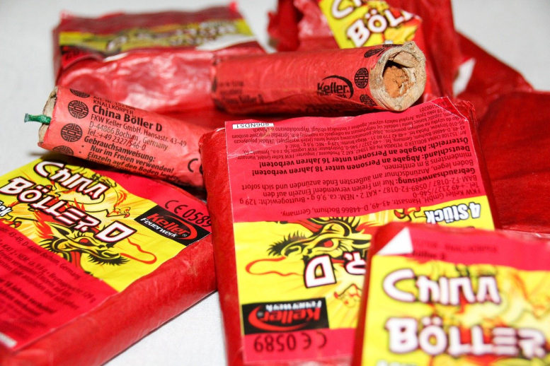 Noch verpackte Böller, zwei einzelne Chinaböller liegen auf einem Haufen zusammen.