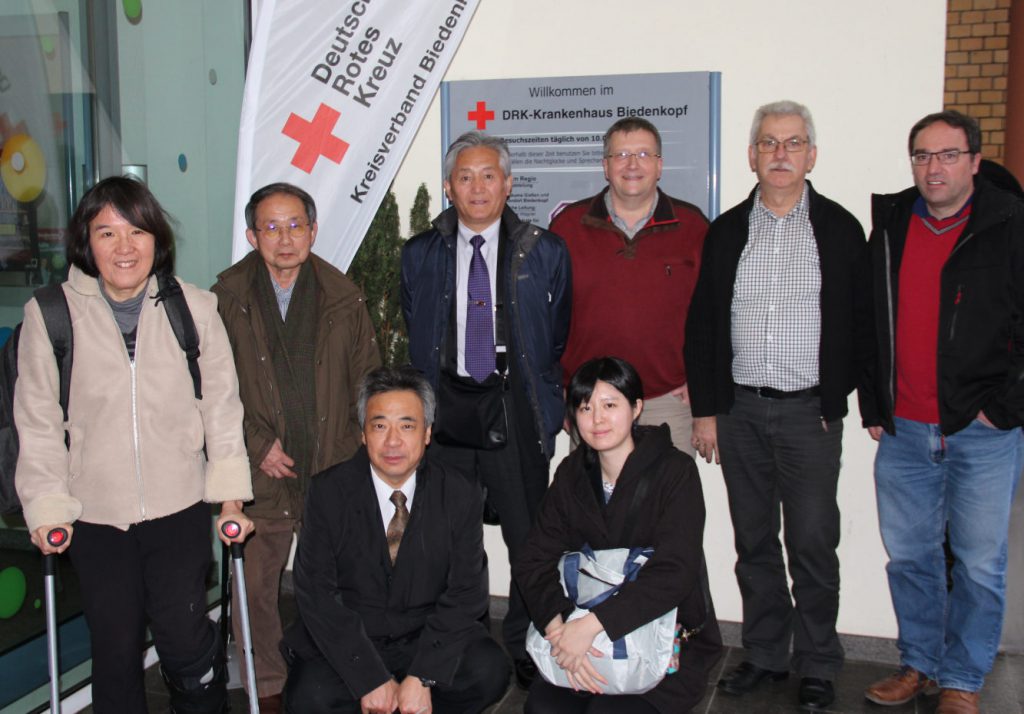 Die Japaner und die DRKler stellen sich zusammen zum Gruppenfoto. Zwei Japaner hocken davor.
