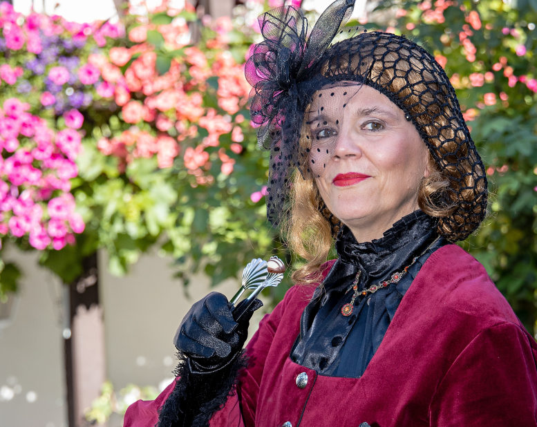 historisch gekleidete Dame mit Pralinenzange.