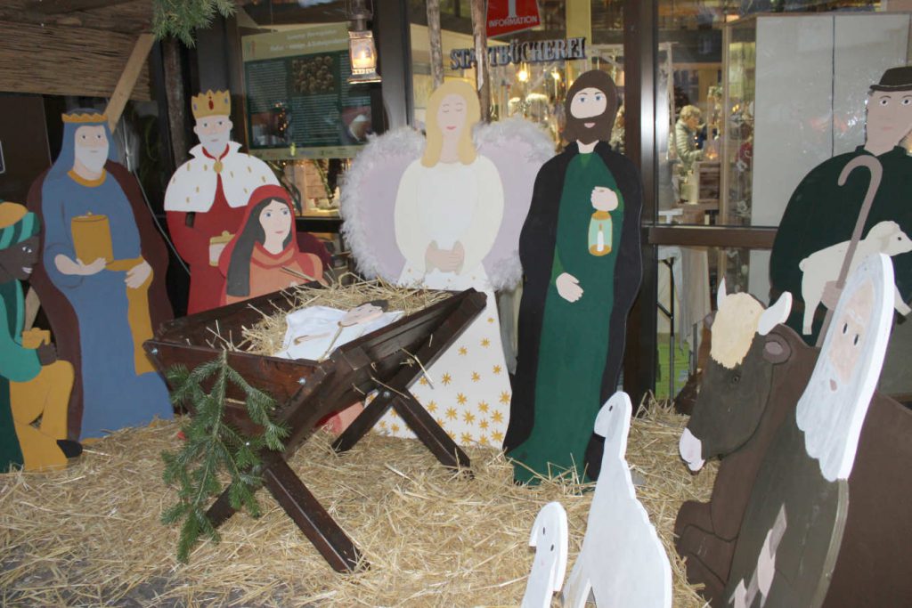 Lebensgroße Weihnachtskrippe mit Figuren aus Holz: Maria und Josef, Könige, Hirten, Schafe und das Jesus-Kind in der Holzkrippe...