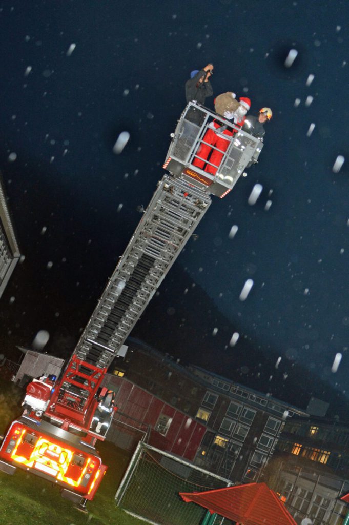 Ein Feuerwehrauto, eine ausgefahrene Drehleiter...und auf ihr in Begleitung eines Feuerwehrmanns und eines Fotografen: der Nikolaus höchstpersönlich.