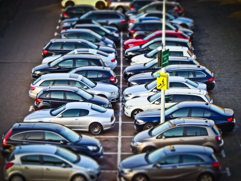 Zwei Reihen Autos stehen parkend auf einem Parkplatz.