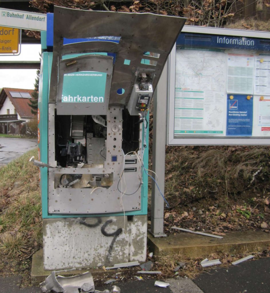 Sprengung eines Fahrkartenautomaten hinterlässt dieses defekte Objekt. Trümmerteile liegen herum.