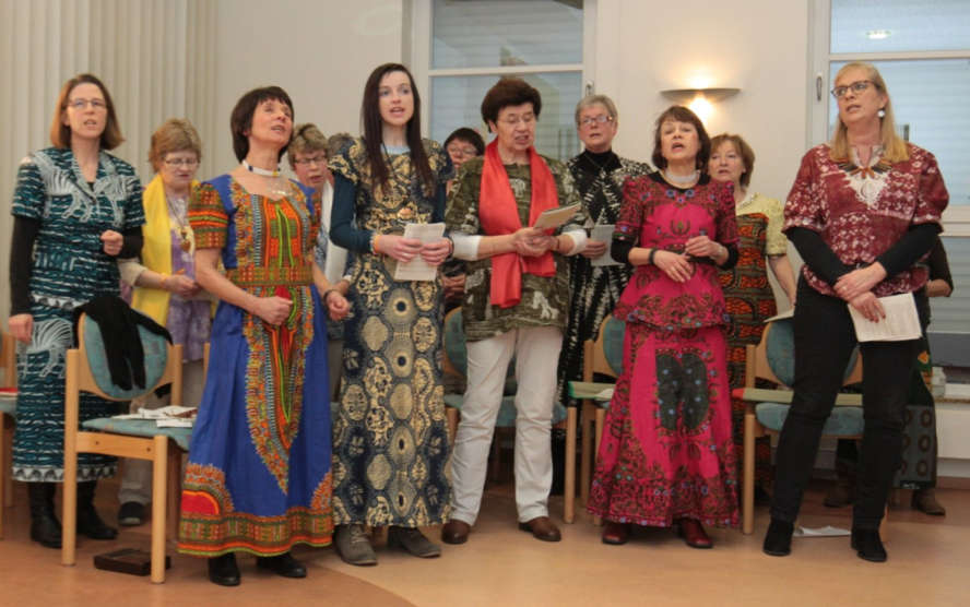 Frauen in afrikanischen Gewändern singen miteinander