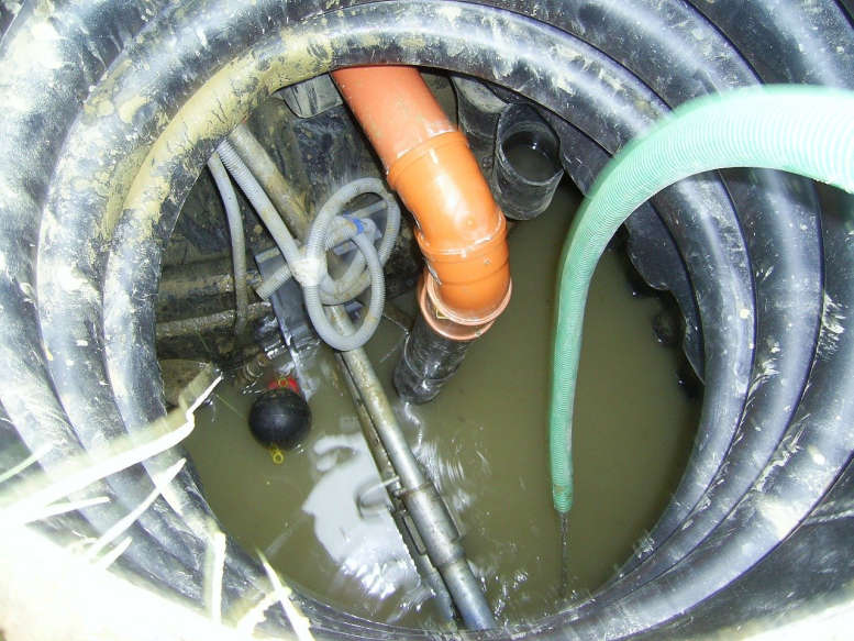 Kanal mit Schläuchen und Rohren und halb mit Wasser gefüllt