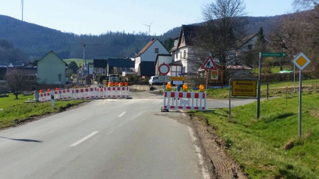 Straßenoberfläche endet. Sperrschilder, dahinter abgefräster Straßenbelag