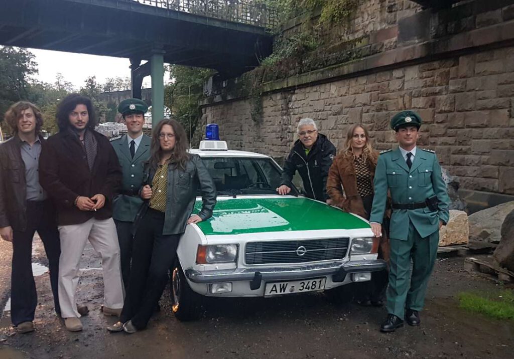 Schauspielern und Komparsen am Opel Rekord aus dem Marburger Polizeioldtimer