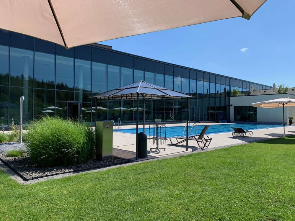 Schwimmbad im Freien und dahinter das Hallenbad.