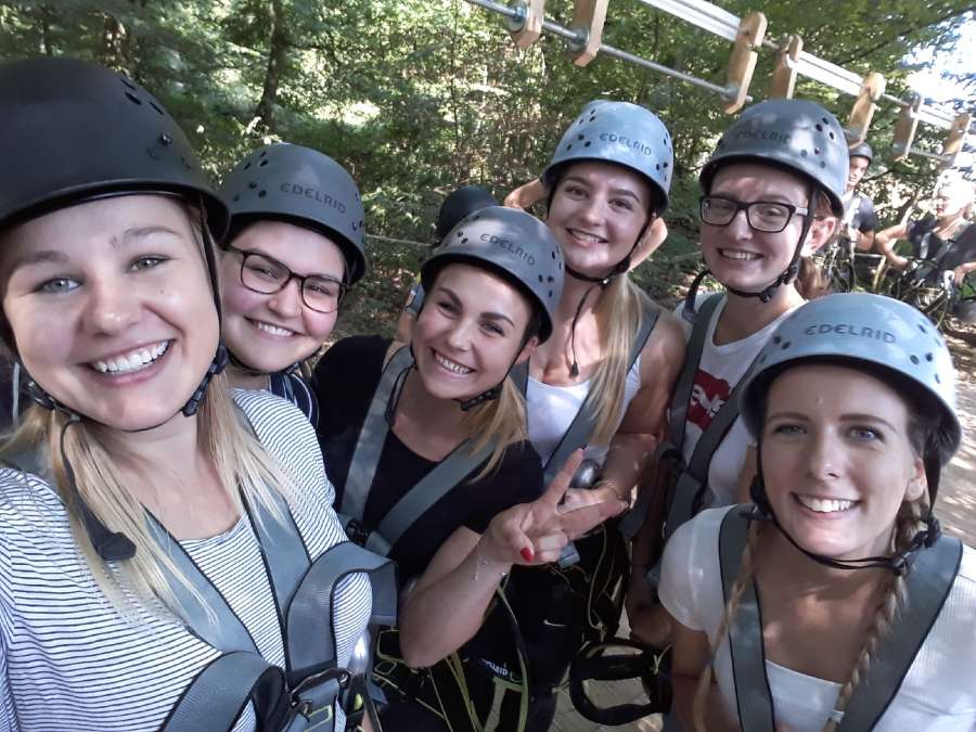 6 Jugendliche mit Helm im Kletterwald. Gruppenfoto.