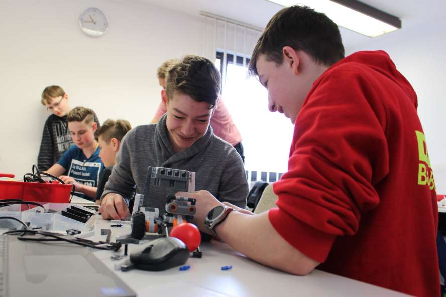 Jugendliche bauen Roboter im Gruppenraum