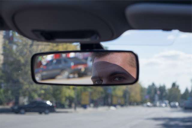 Innenraum im Auto. Mann schaut in den Rückspiegel