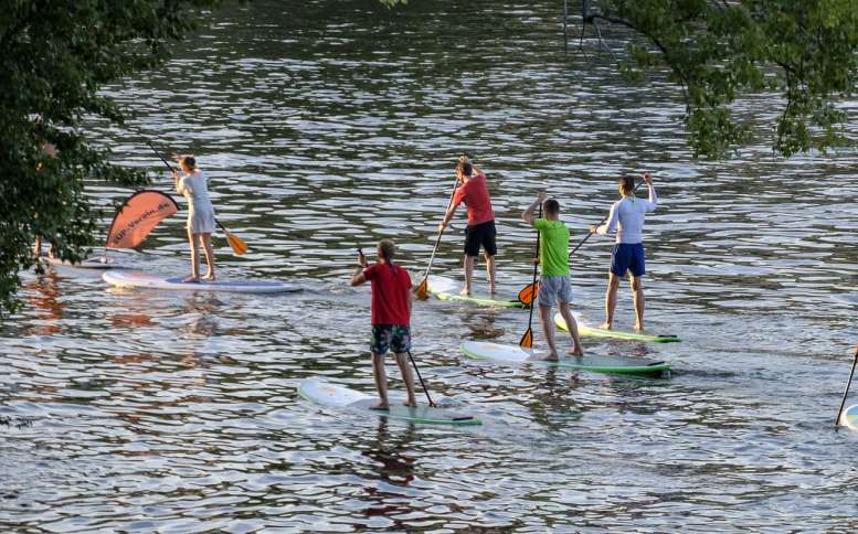 6 Jugendliche auf einem Fluss - beim Stand-Up-Paddling