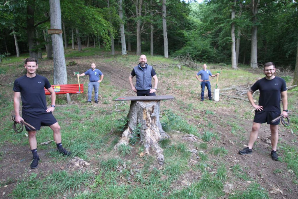 5 Männer im Wald. Mit Äxten und Peitschen trainieren sie.
