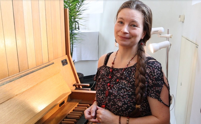 Frau im Sommerkleid an einer Orgel