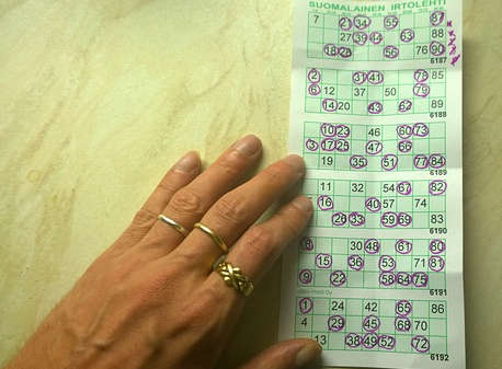 Eine Hand hält einen Bingoschein fest