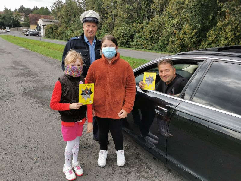 Polizist mit 2 Mädchen am Auto eines pkw-Fahrers