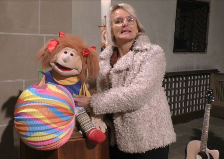 Frau mit Handpuppe und Gitarre