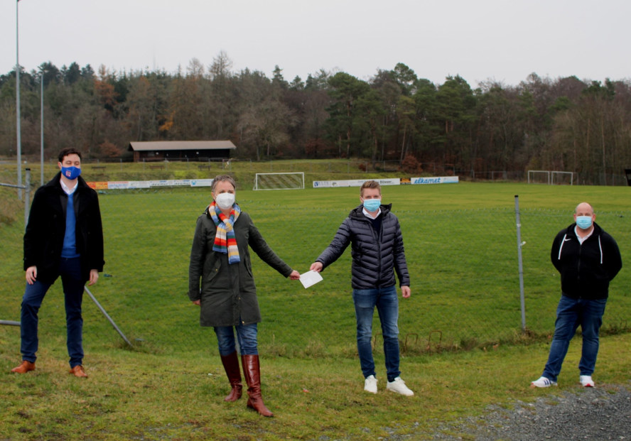 Landrätin und drei Männer vor dem Sportplatz