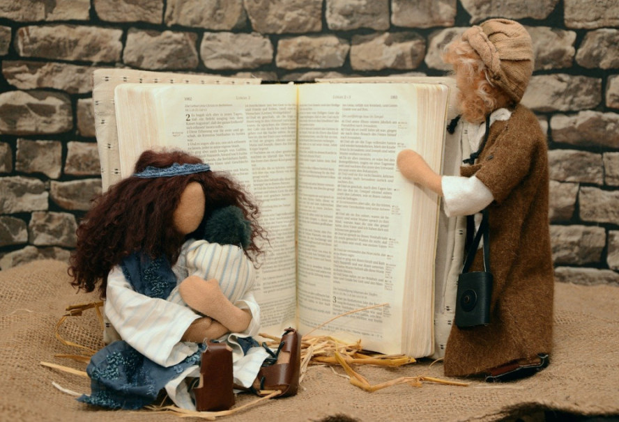 Die Heilige Familie als Egli-Figuren vor einer aufgeschlagenen Bibel