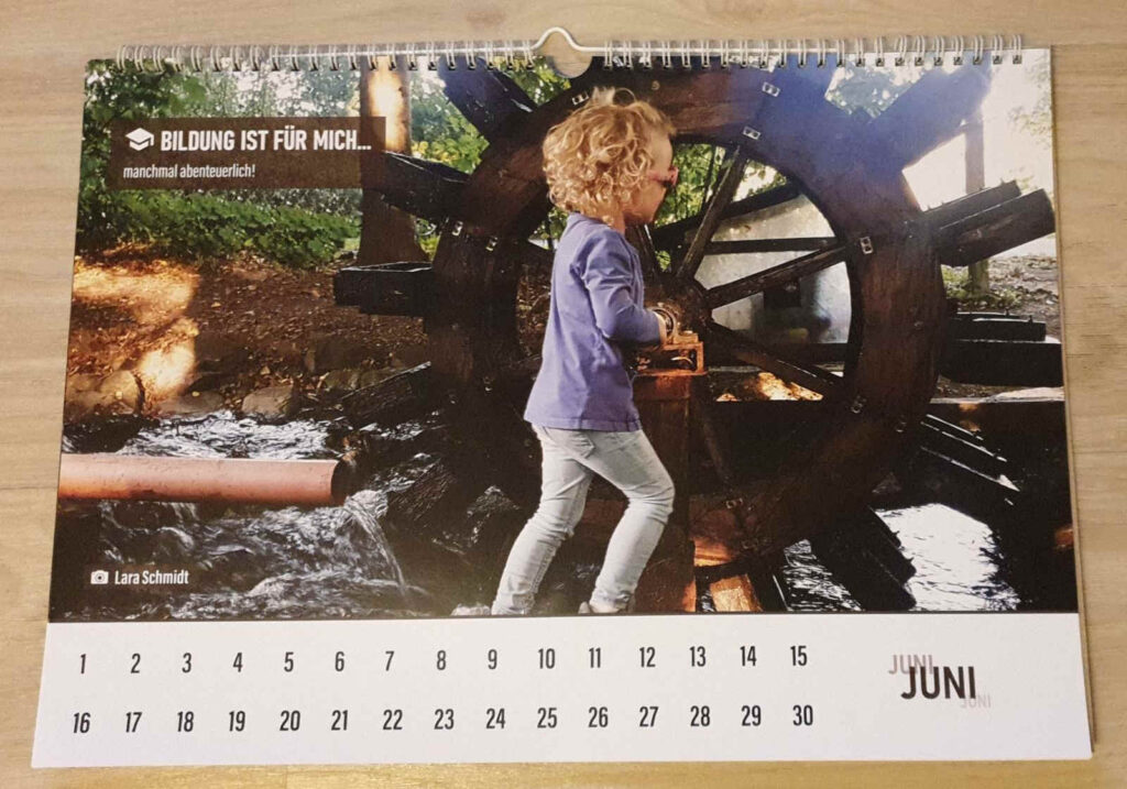 Kalenderbild: Kleines Mädchen dreht am Wasserrad
