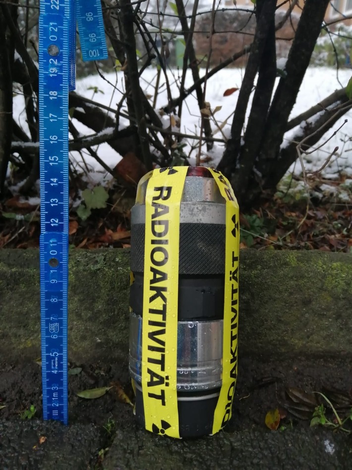 Merkwürdiger Behälter mit Aufschrift "radioaktiv" hängt an einem Baum.