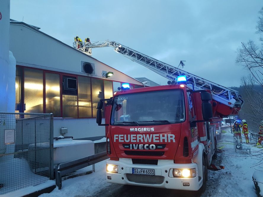 Feuerwehrleute beim Löschen in einem Betrieb (von außen)