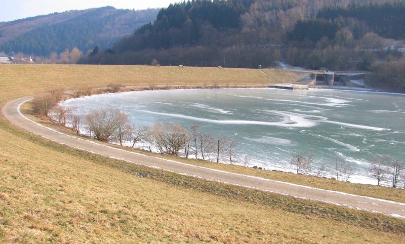 zugefrorener Perfstausee mit Staumauer