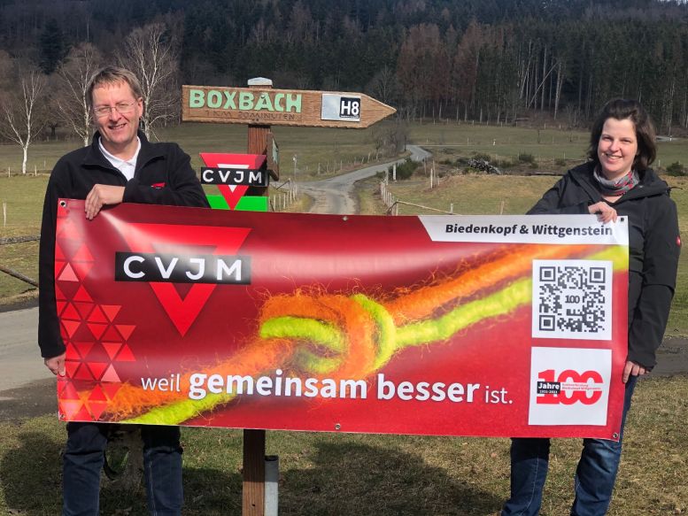 Mann und Frau halten ein Werbeplakat