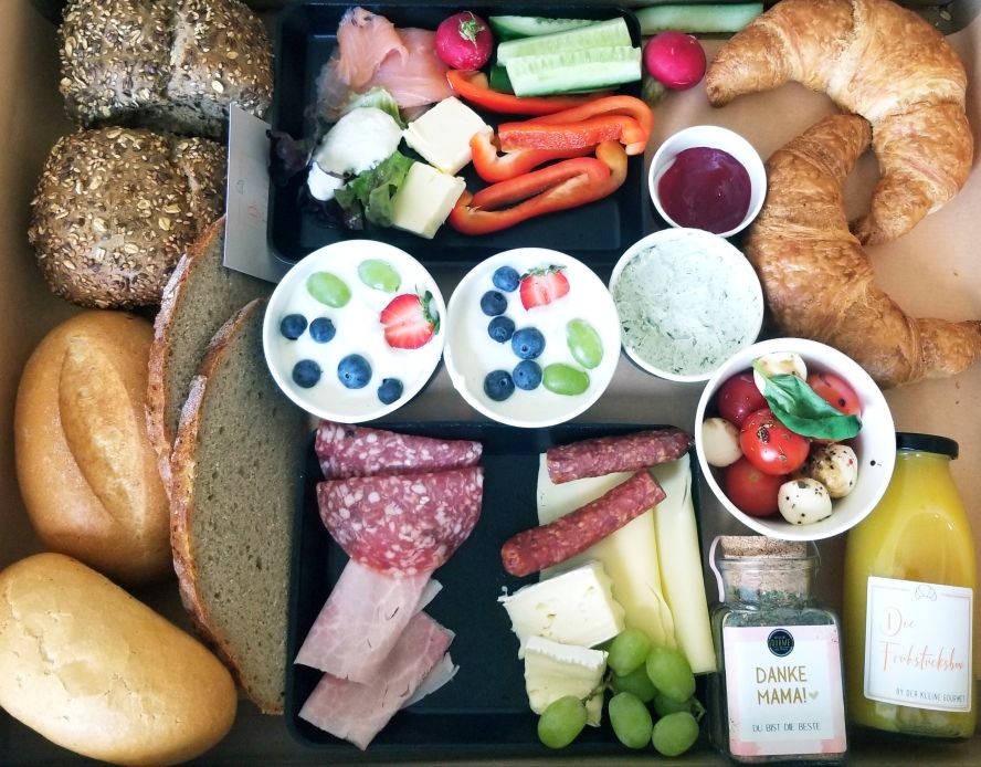 Box mit Brot, Croissants, Dips, Saft und mehr.