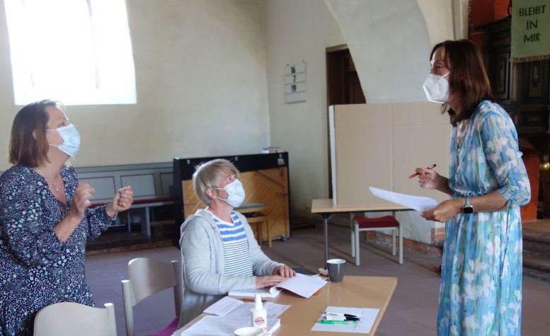 3 Frauen mit Mundlappen in einer Kirche
