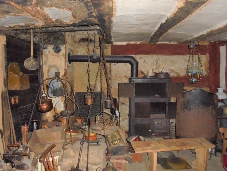 historische Küche mit Holzofen und alten Utensilien