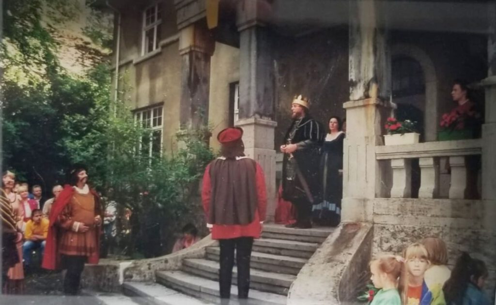 Historisch gewandete Menschen an einem Schloss