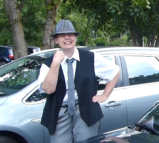 Als Mann verkleidete Frau vor einem Auto