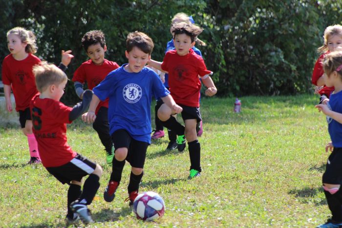 Kinder spielen Fußball auf dem Rasen