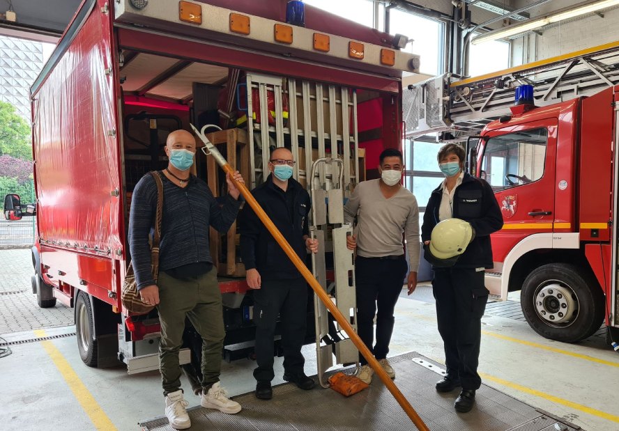 4 Leute mit Maske vor Feuerwehrfahrzeug