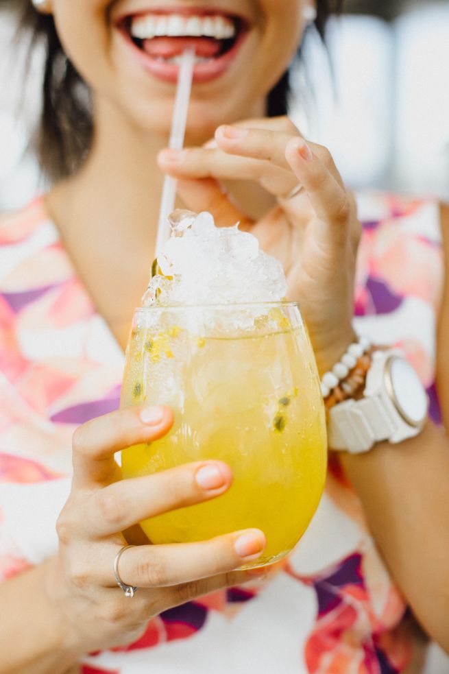 Frau trinkt gelben Cocktail