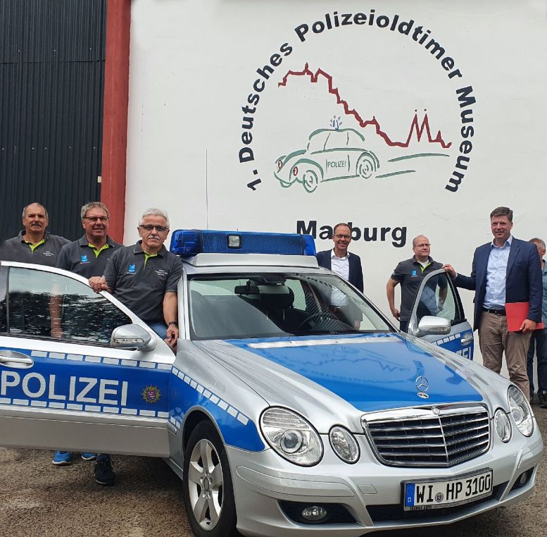 6 Offizielle bei einem Polizeioldtimer (Mercedes) vom Typ E280 CDI,
