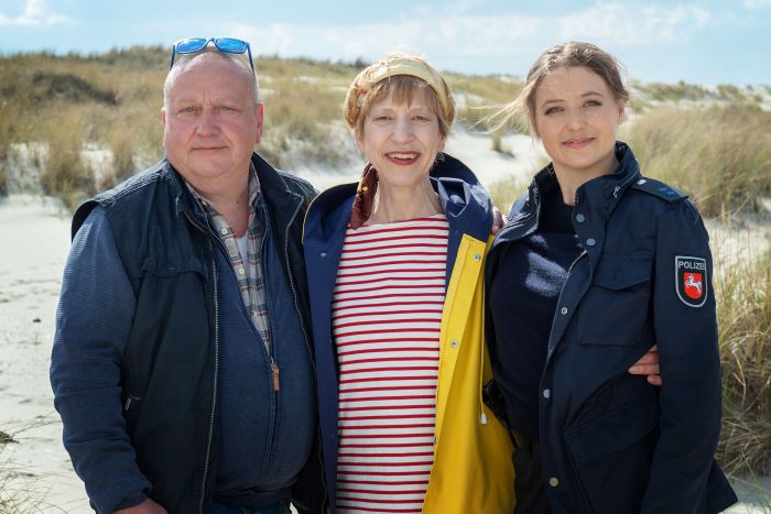 Mann und zwei Frauen in den Dünen.