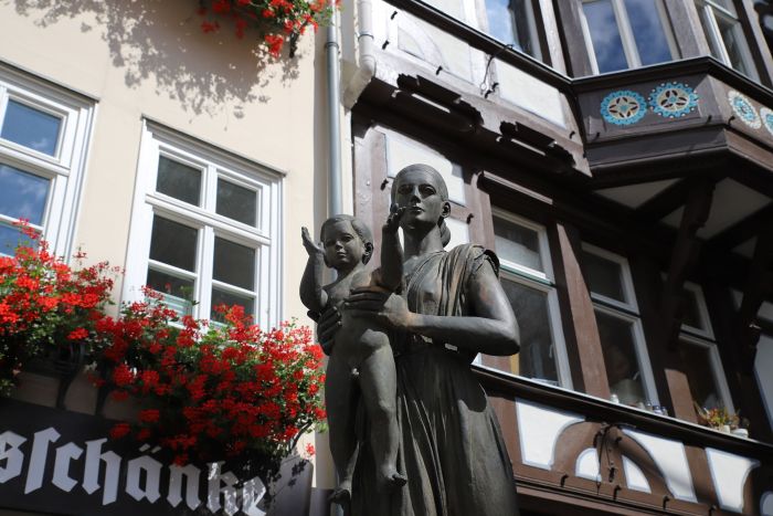 Denkmal: Frau mit Kind vor Fachwerkgebäude