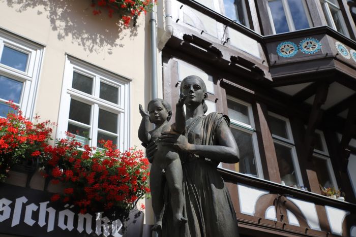 Denkmal: Frau mit Kind vor Fachwerkgebäude