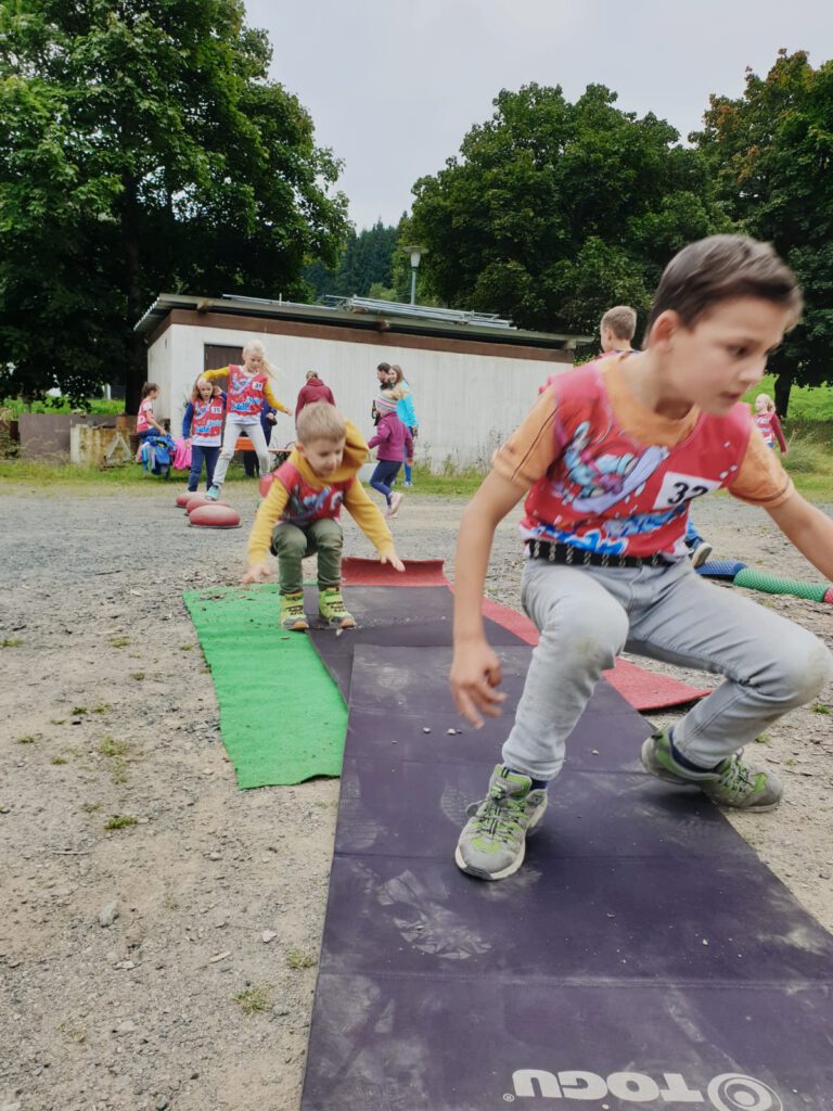 Kinder springen auf einem Parcours