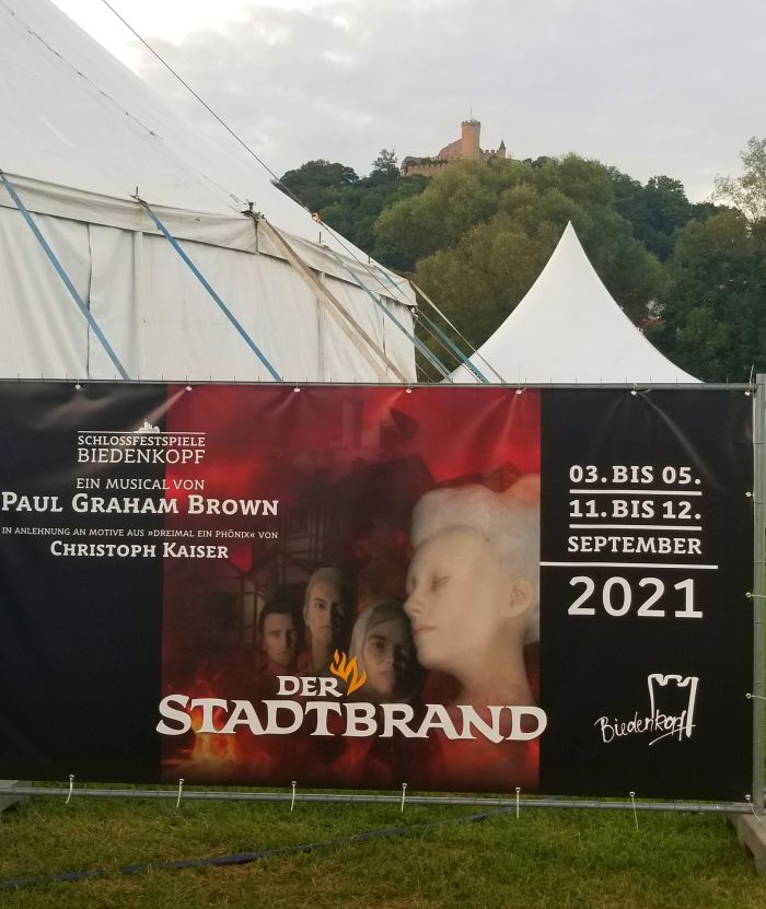 Plakat vom Stadtbrand vor dem Biedenkopfer Schloss im Hintergrund