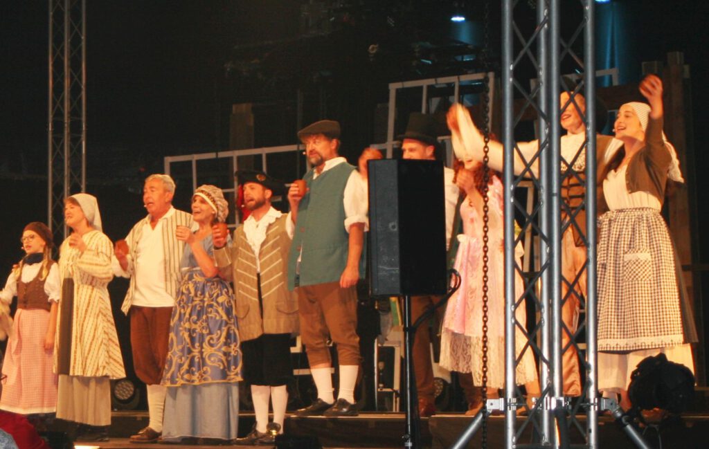 Darsteller singen und tanzen in historischen Kostümen