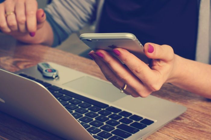 Frauenhände, PC und Smartphone